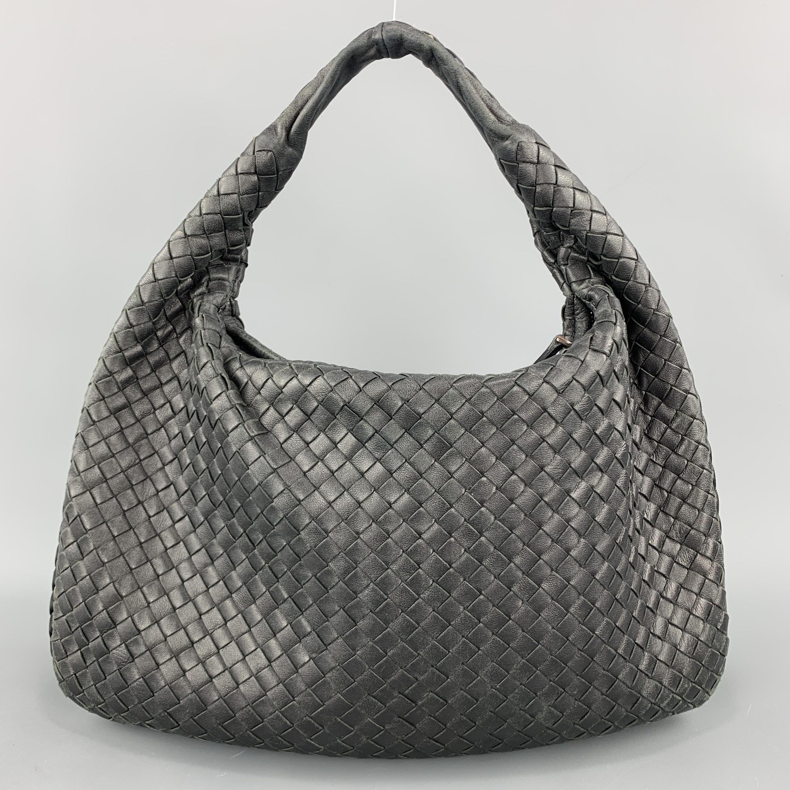 Metallic-grey woven bag with knotted handle; exact size and leather unverified