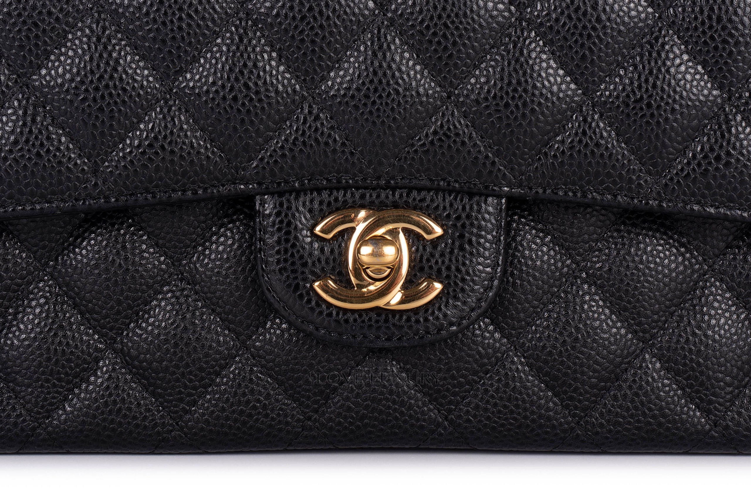 Close-up of black grained quilted flap with CC motif and gold-tone fastening